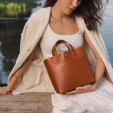 Honey Classic | Model holding crossbody tote bag with snap closure and front pocket