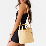 Vanilla Classic | Model holding crossbody tote bag with snap closure and front pocket