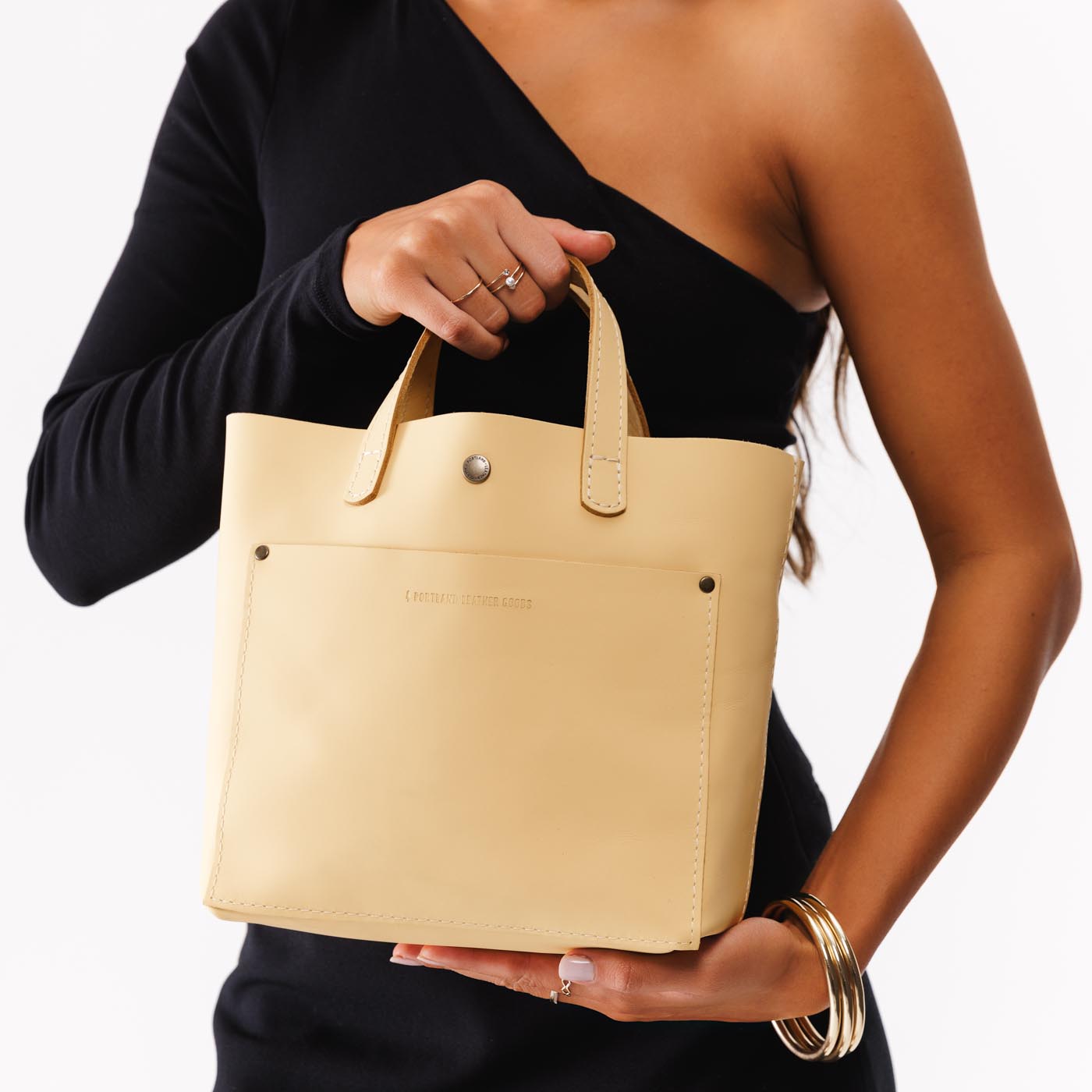 Vanilla*Classic | Model holding crossbody tote bag with snap closure and front pocket