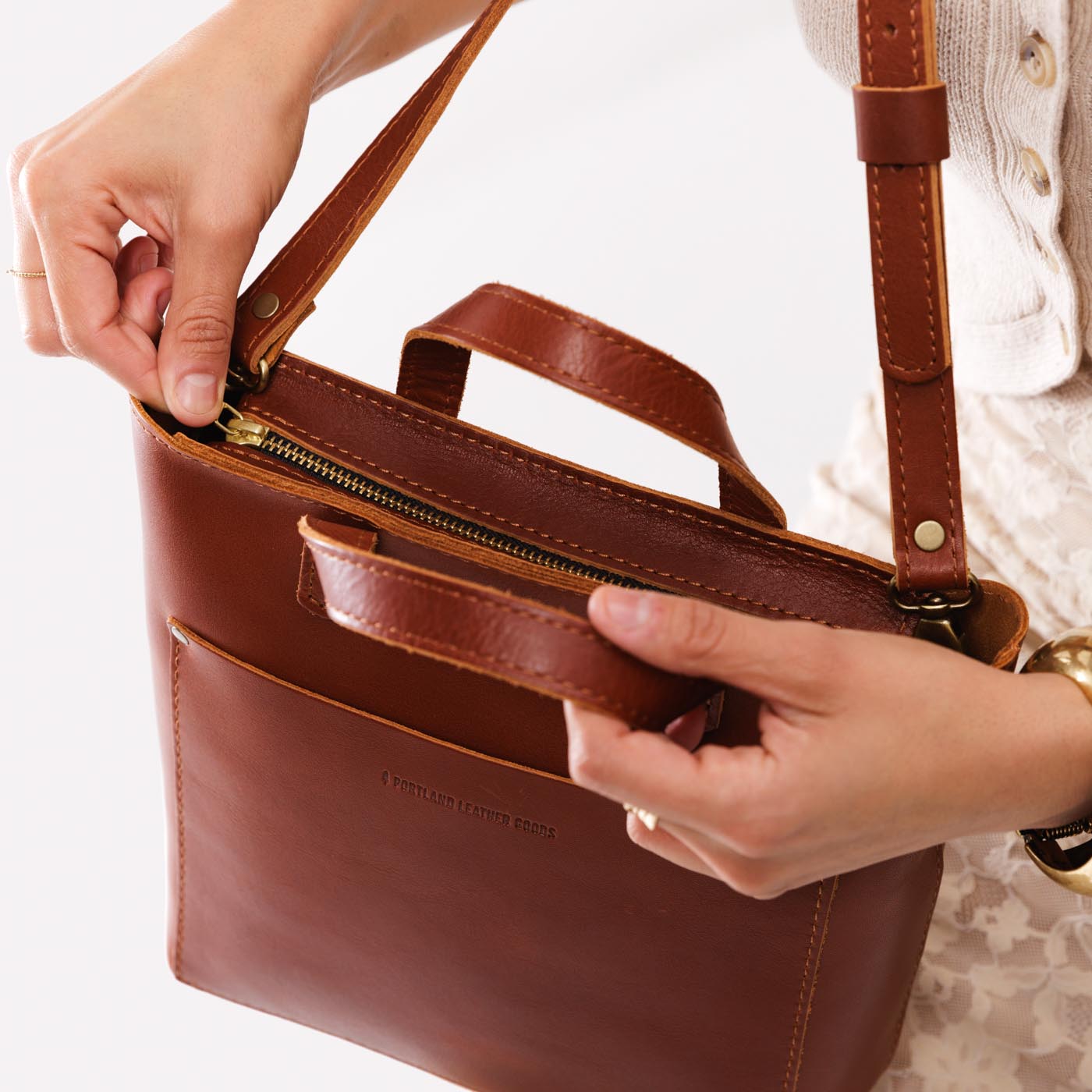 Chestnut*Zipper | Model holding crossbody tote bag with zipper closure and front pocket