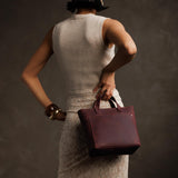 Merlot Zipper | Model holding crossbody tote bag with zipper closure and front pocket