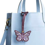 Plum | Embroidered butterfly tassel accessory on a bag