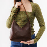 Coldbrew Small | Model holding petite shoulder bag with adjustable strap and magnetic snap closure