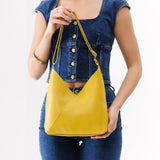 Naples Small | Model holding petite shoulder bag with adjustable strap and magnetic snap closure