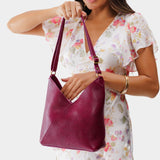 Orchid Small | Model holding petite shoulder bag with adjustable strap and magnetic snap closure