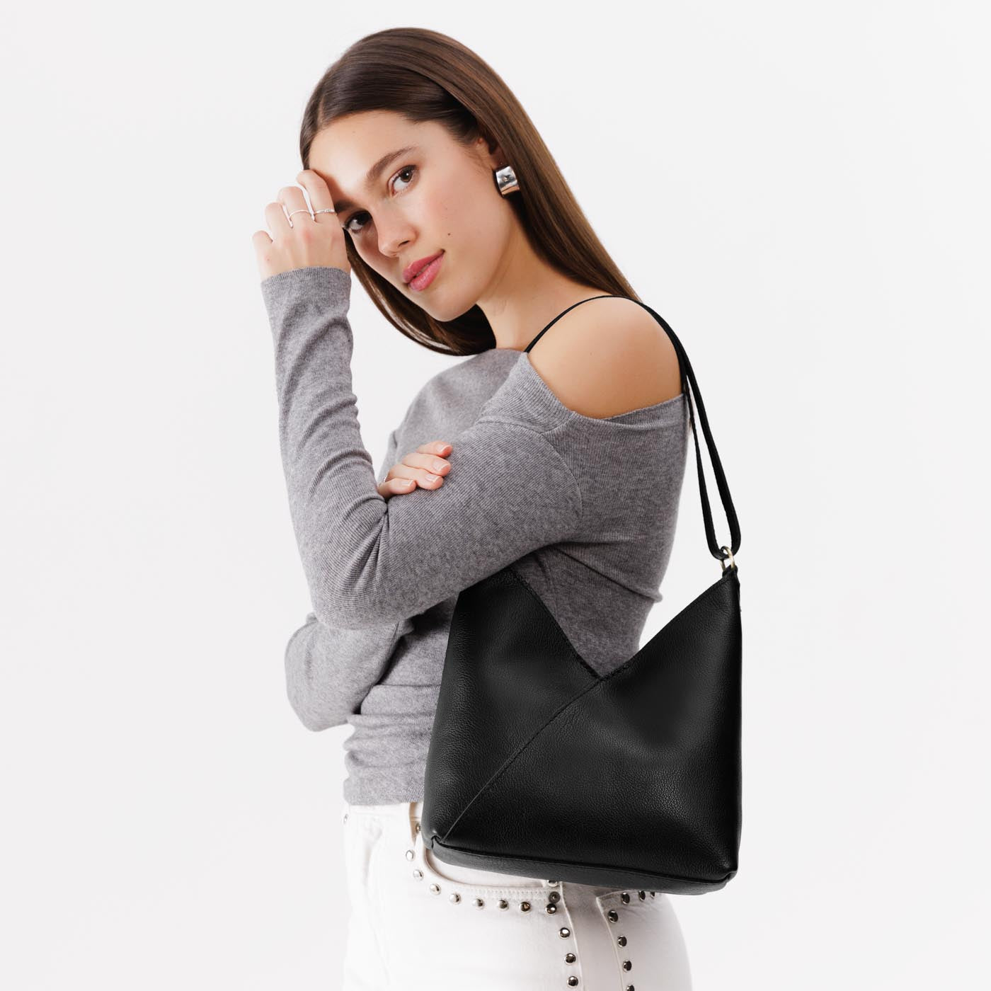 Pebbled--black*Small | Model wearing petite shoulder bag with adjustable strap and magnetic snap closure