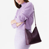 Plum Small | Model wearing petite shoulder bag with adjustable strap and magnetic snap closure