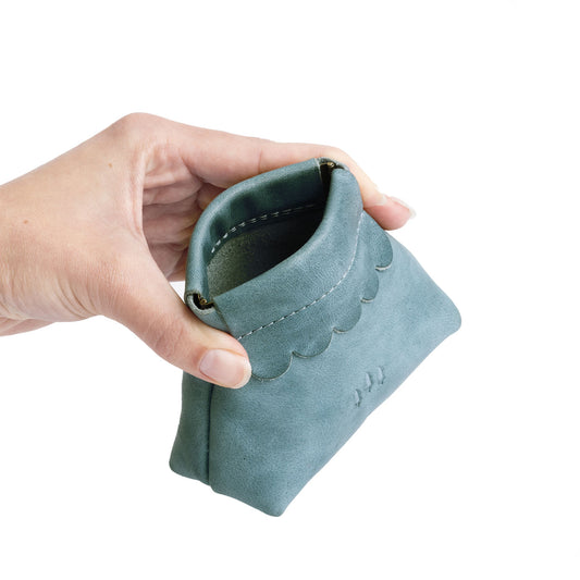 Aqua | Hand holding leather coin pouch with scalloped edge and three Portland leather tree emblems open