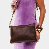 Coldbrew | Model holding midsize zip top crossbody bag with detachable strap