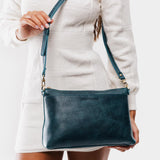 Lagoon | Model holding midsize zip top crossbody bag with detachable strap