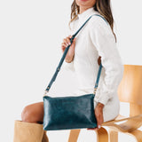 Lagoon | Model holding midsize zip top crossbody bag with detachable strap