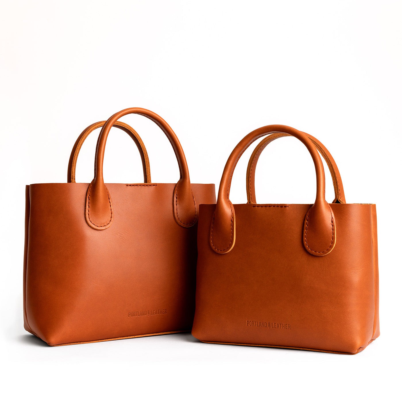 Tuscany | Side by side of both tote purses with structured leather handles and crossbody strap