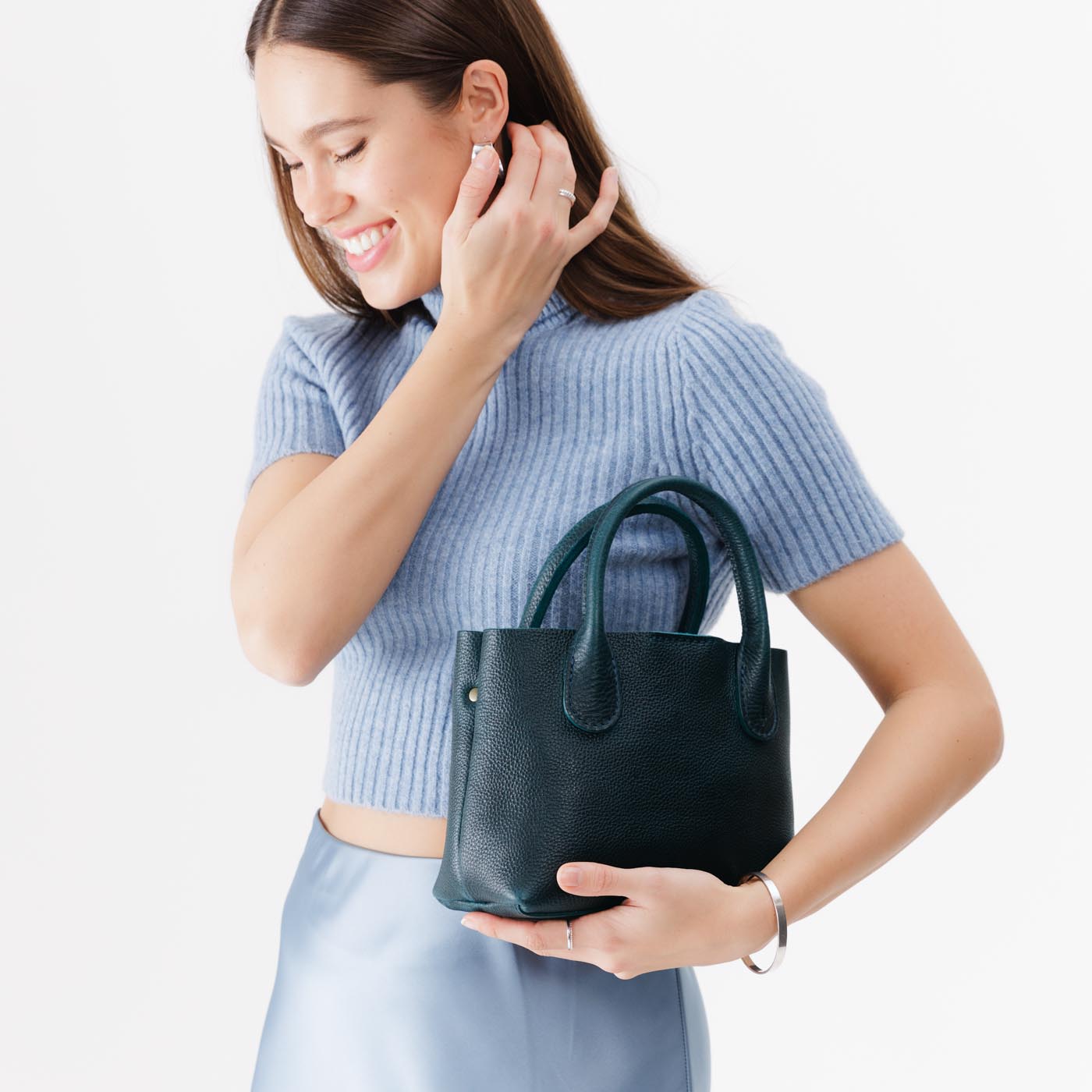 Boreal*Small | Model holding mid-size tote purse with  structured leather handles and crossbody strap