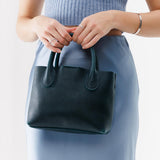 Boreal Small | Model holding mid-size tote purse with  structured leather handles and crossbody strap