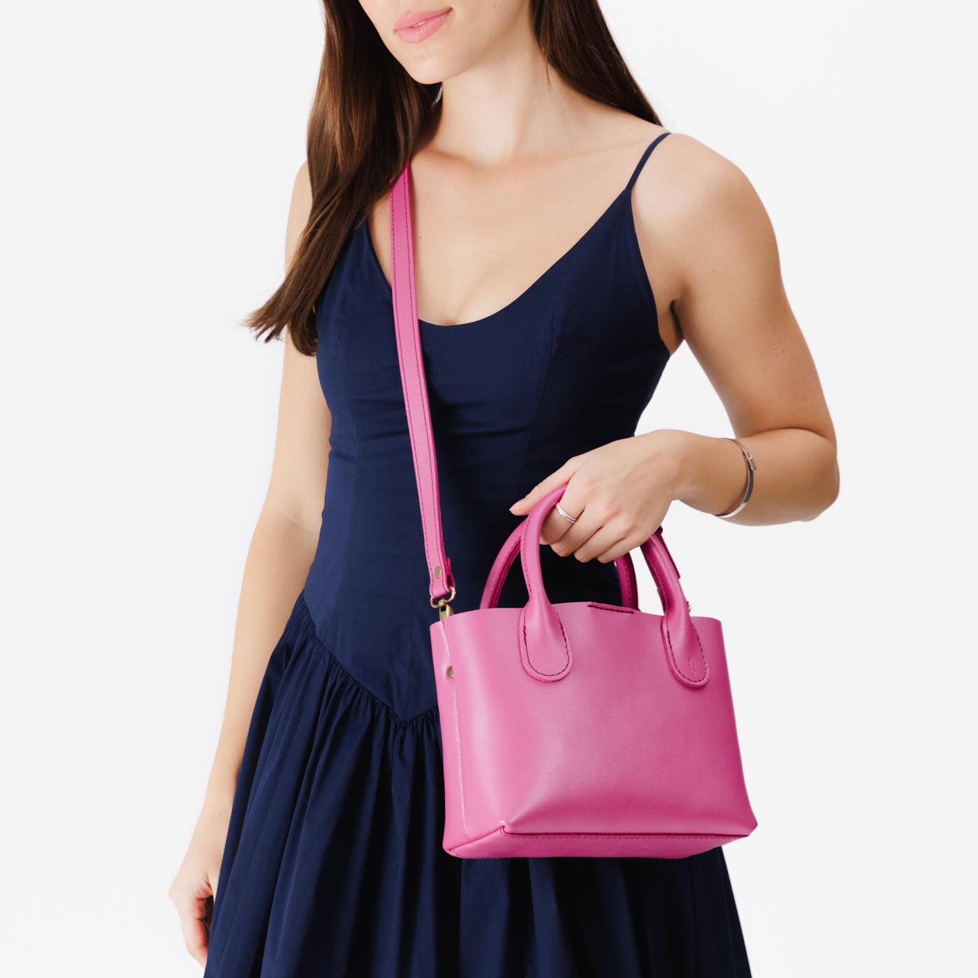 Lip Gloss*Small | Model holding mid-size tote purse with  structured leather handles and crossbody strap