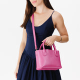 Lip Gloss Small | Model holding mid-size tote purse with  structured leather handles and crossbody strap