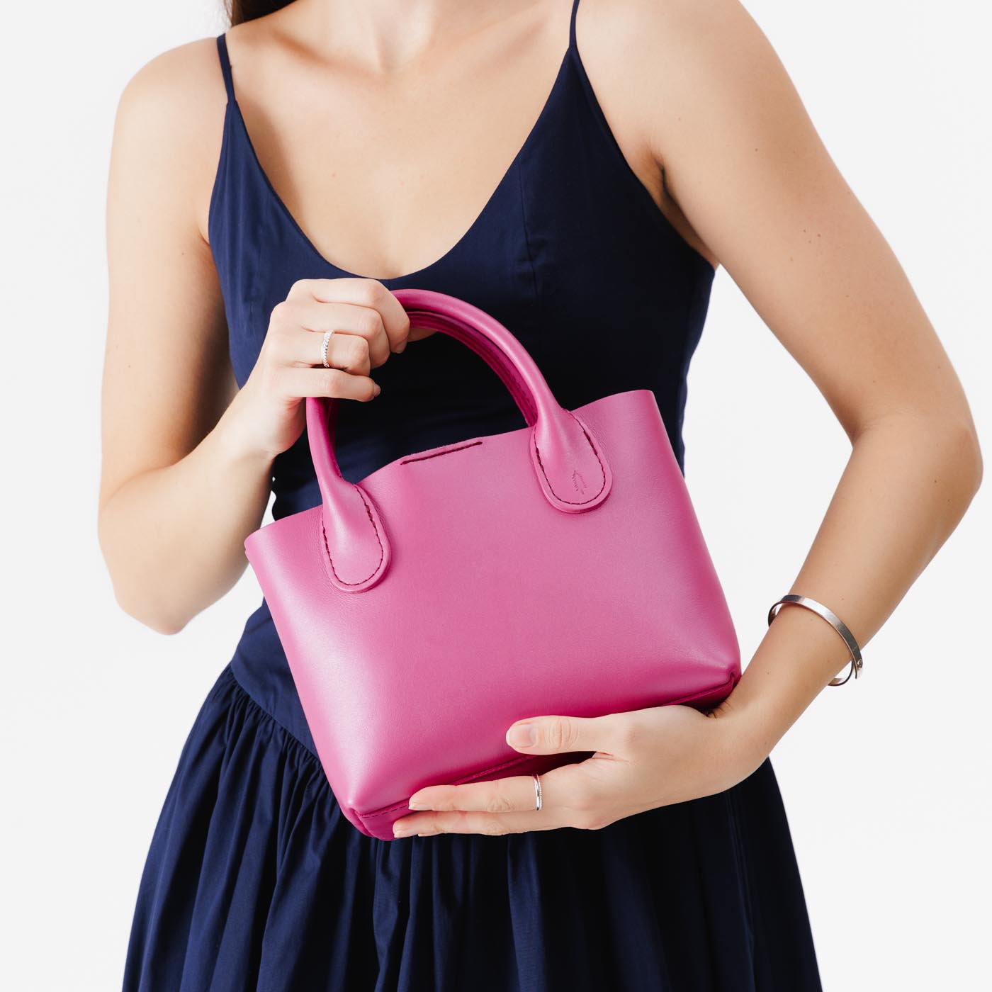 Lip Gloss*Small | Model holding mid-size tote purse with  structured leather handles and crossbody strap