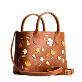 Folklore Honey Large | Mid-size tote purse with embroidered flower design, structured leather handles, and crossbody strap