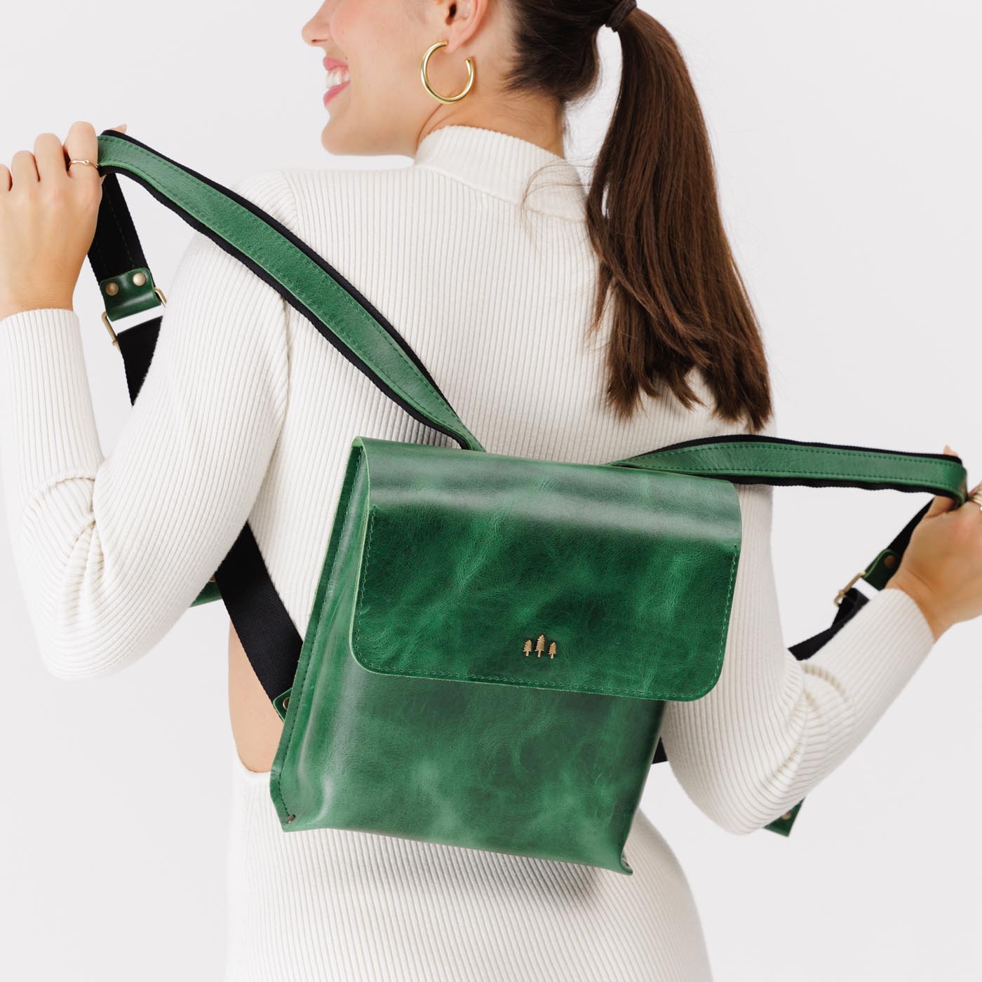 Cowboy Mint | Model holding rectangular backpack with leather lined nylon straps and magnetic flap closure