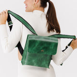 Cowboy Mint | Model holding rectangular backpack with leather lined nylon straps and magnetic flap closure