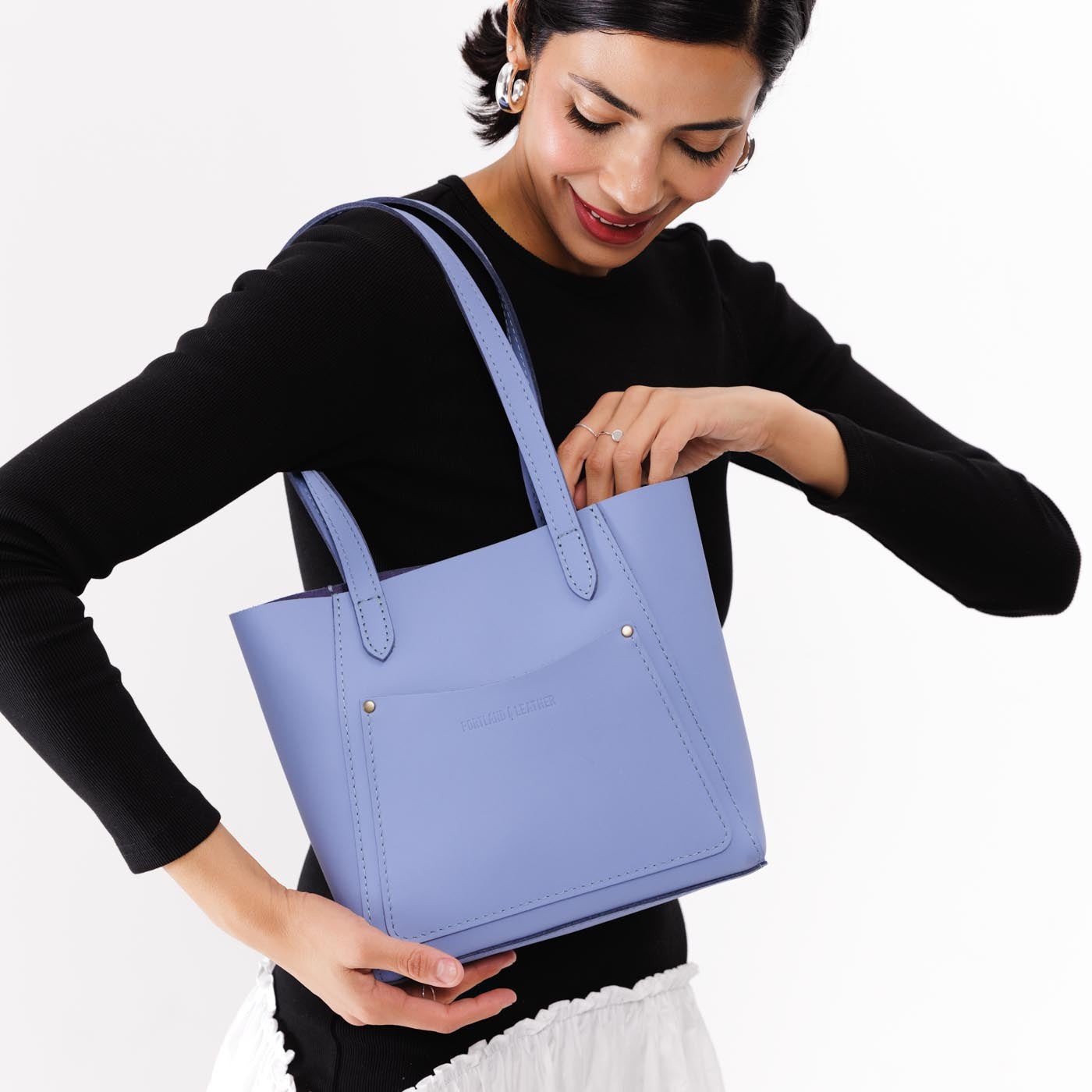 Jacaranda*Small | Model holding dual shoulder strap tote bag with an exterior pocket