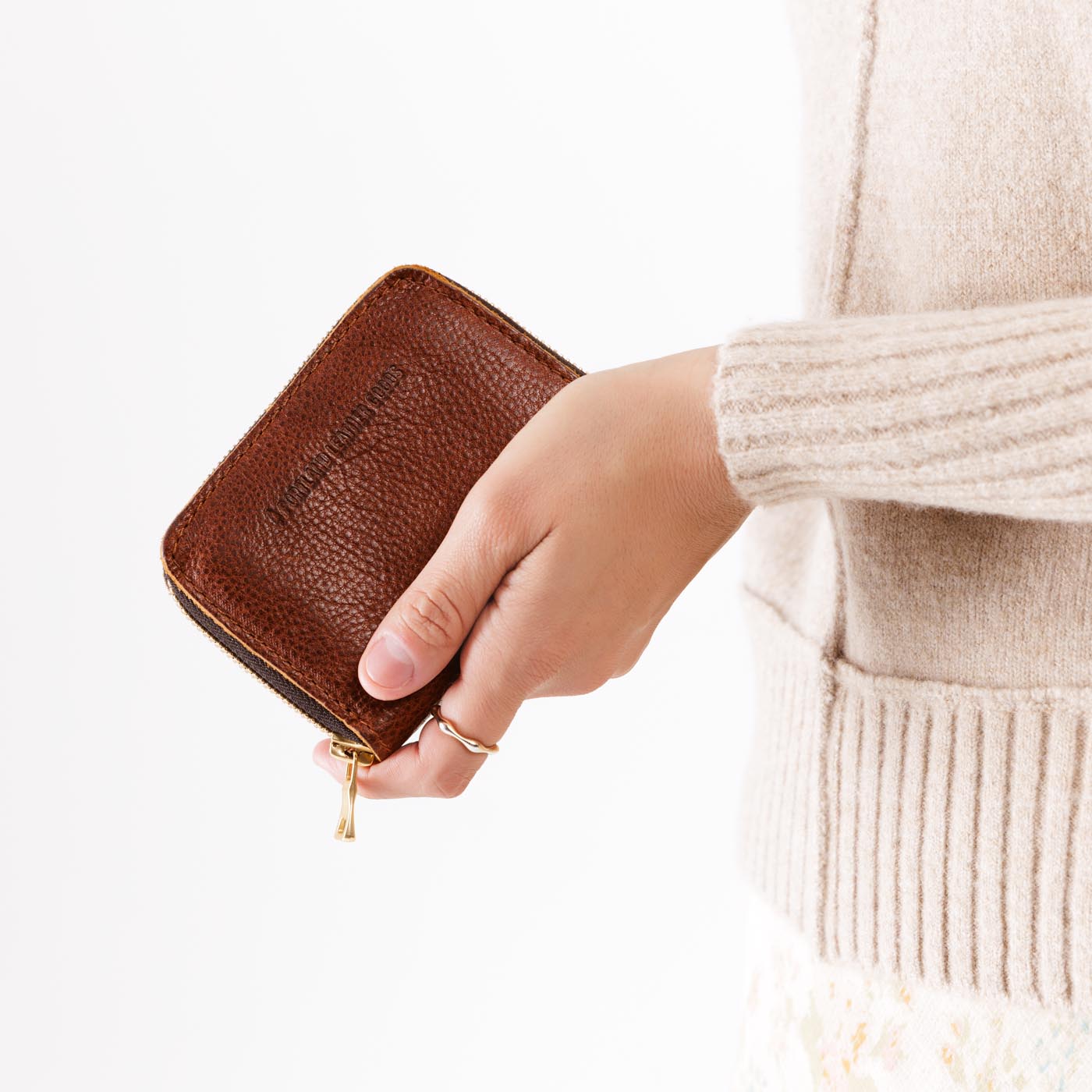 Nutmeg | Model holding small leather wallet with zipper closed