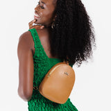 Shortbread | Model wearing small sling bag with zipper closure and adjustable strap on her back