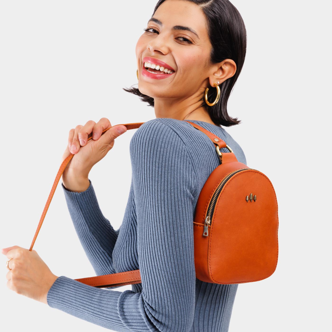 Tuscany | Model wearing small sling bag with zipper closure and adjustable strap