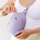 Wisteria | Model opening small sling bag with zipper closure and adjustable strap