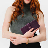 Plum | Model holding leather wallet with snap closed