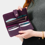 Plum | Model holding leather wallet with snap open