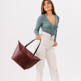 Cognac Zipper | Model holding large zipper leather tote bag with sturdy bridle handles and front pocket