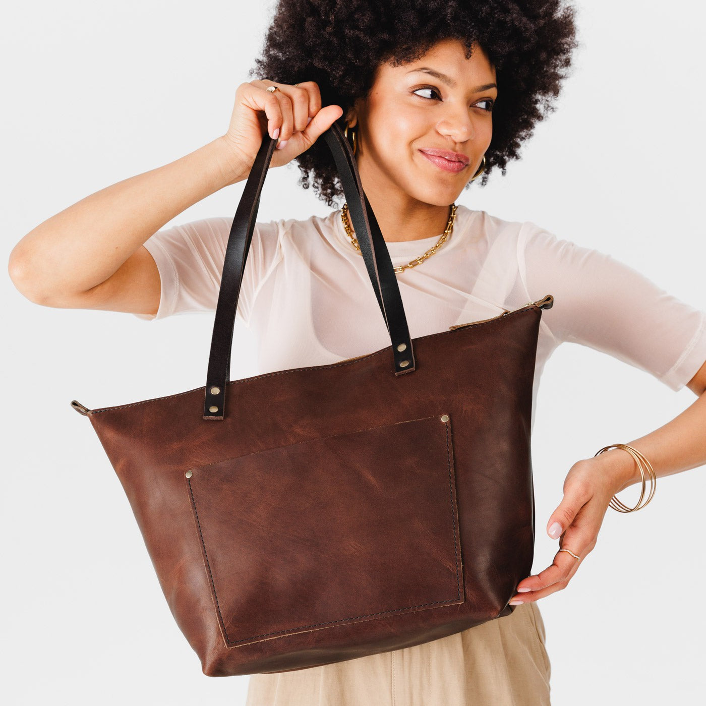 Durango*Zipper | Model holding large leather tote bag with sturdy bridle handles and front pocket