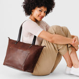 Durango Zipper | Model holding large leather tote bag with sturdy bridle handles and front pocket