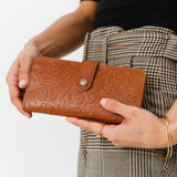 Meadow | Model holding leather wallet with snap closed