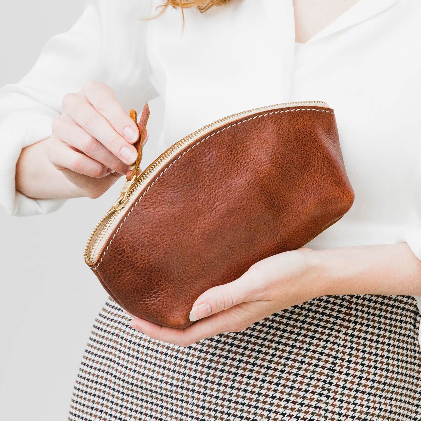 All Color: Nutmeg | Spacious leather makeup bag with curved seams and top zipper